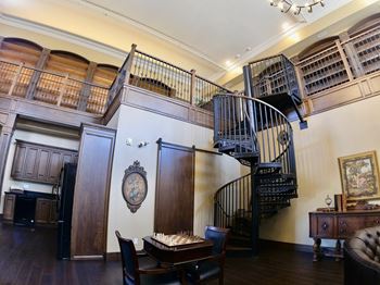 Creekside common room chess table and chairs in a room with a staircase and bookshelves